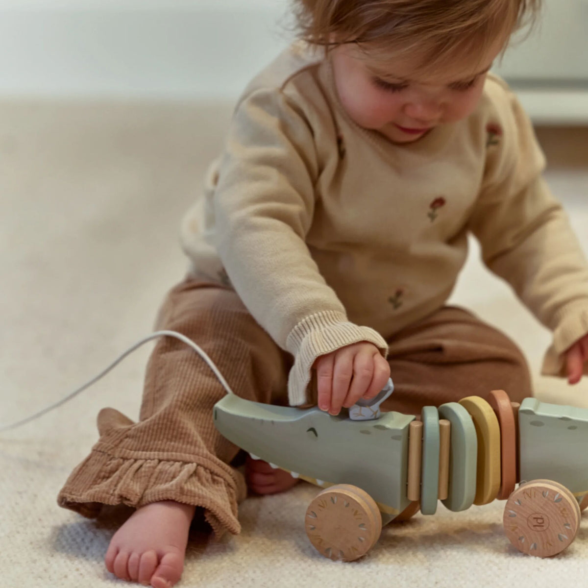 Child playing with crocodile toy